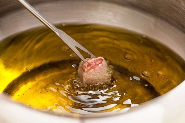 Aceite de oliva en cazo con trozo de carne