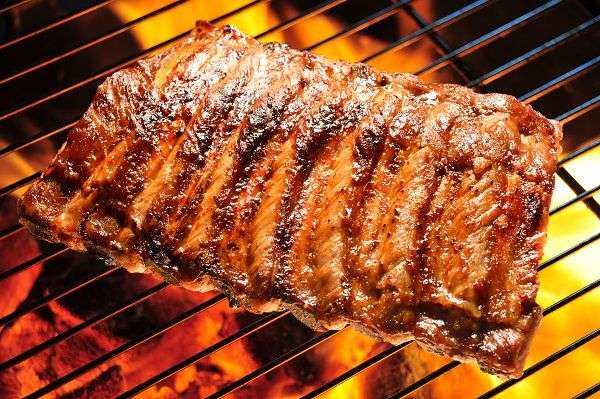 Costillas adobadas en la rejilla de la barbacoa 