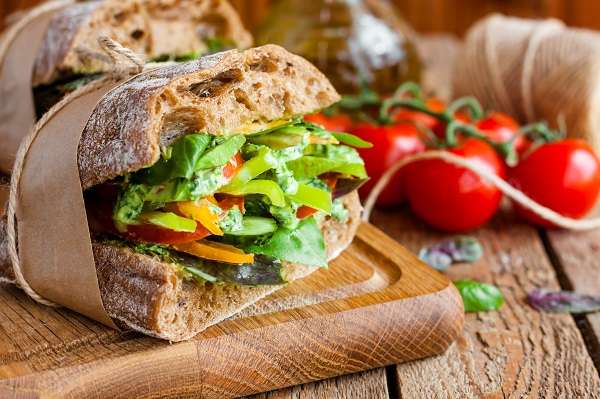 Pan relleno de ensalada envuelto sobre papel