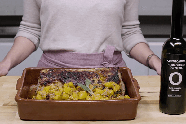 Asado de cerdo con ragout de calabaza en cazuela de barro sobre tabla de madera