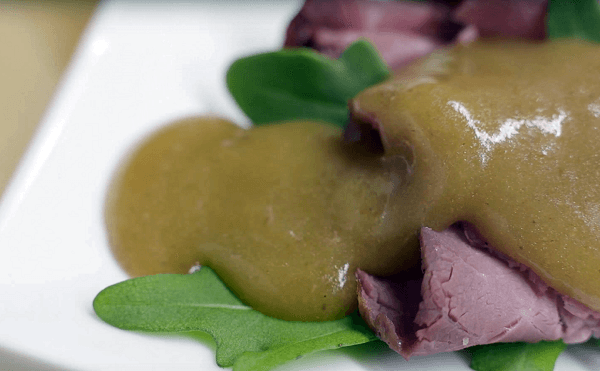 salsa gravy sobre rosbif y lechuga en plato blanco 