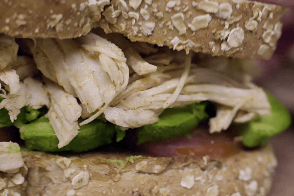 Detalle de sándwich de pollo mechado con paprika y aguacate