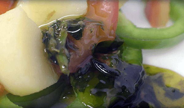 Vinagreta de albahaca sobre ensalada de patata, tomate y pimiento. 