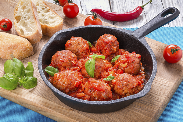 Sartén con albóndigas con tomate y albahaca