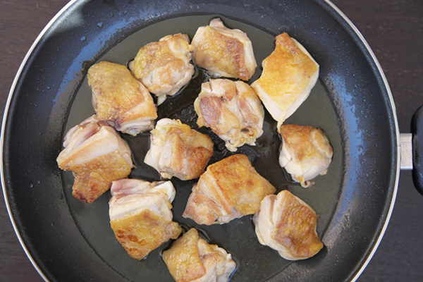 Dorar el pollo en una sartén con aceite de oliva virgen extra para la paella