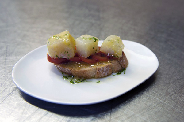 Montadito con bacalao ahumado, tomates cherry, albahaca y puré de aceitunas negras